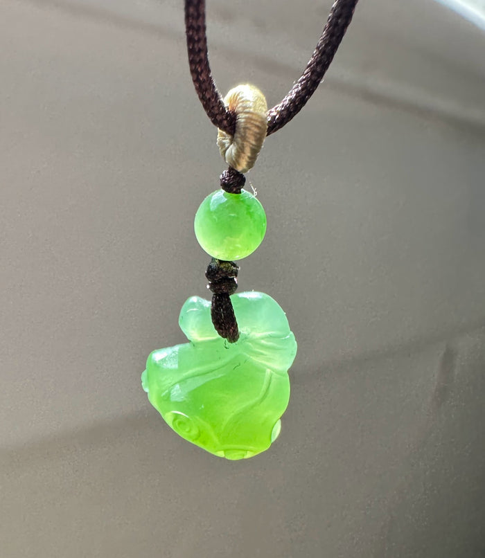 Apple Siberian Jade lotus seed pod pendant on a dark brown braided cord with a bright green bead