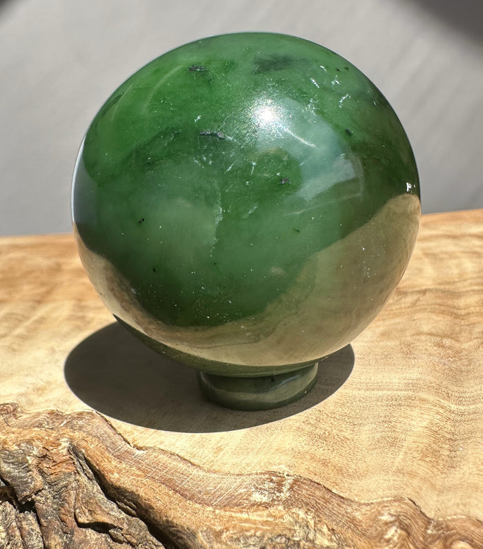 Green jade sphere on a wooden surface