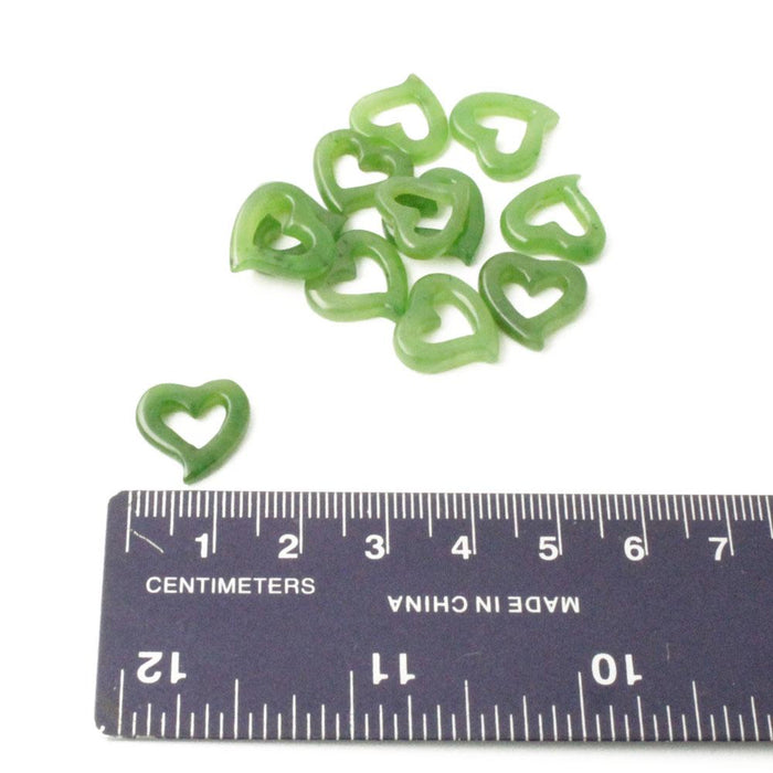 Green translucent heart charm next to a ruler for scale