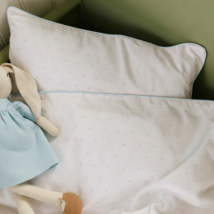 Baby pillow with soft texture and a plush toy on a green background