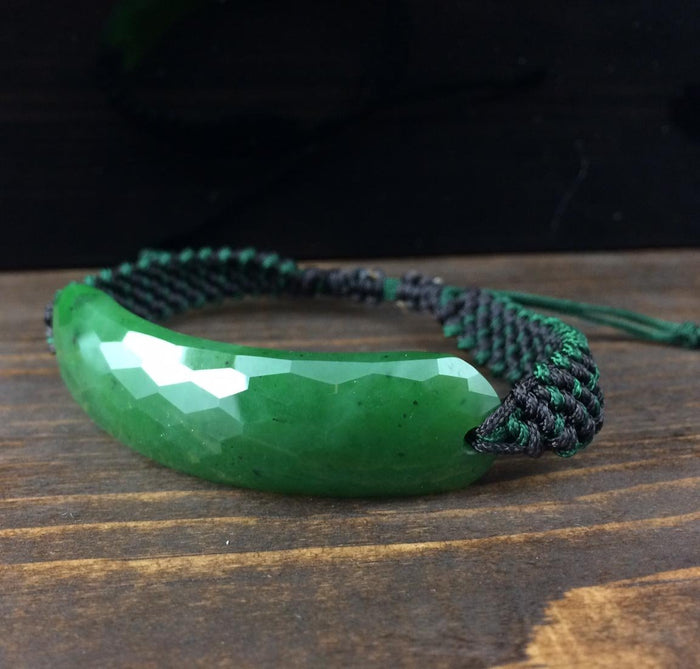 Green faceted jade bracelet on a green and black braided cord