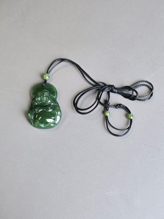 Green jade Laughing Buddha pendant on black cord with a small green bead