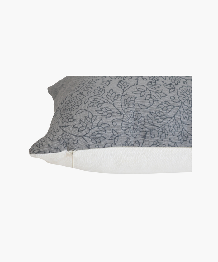 A detailed picture of a pillow highlighting its delicate gray floral pattern. The design features intertwined flowers and leaves, conveying a soft, elegant feel.
