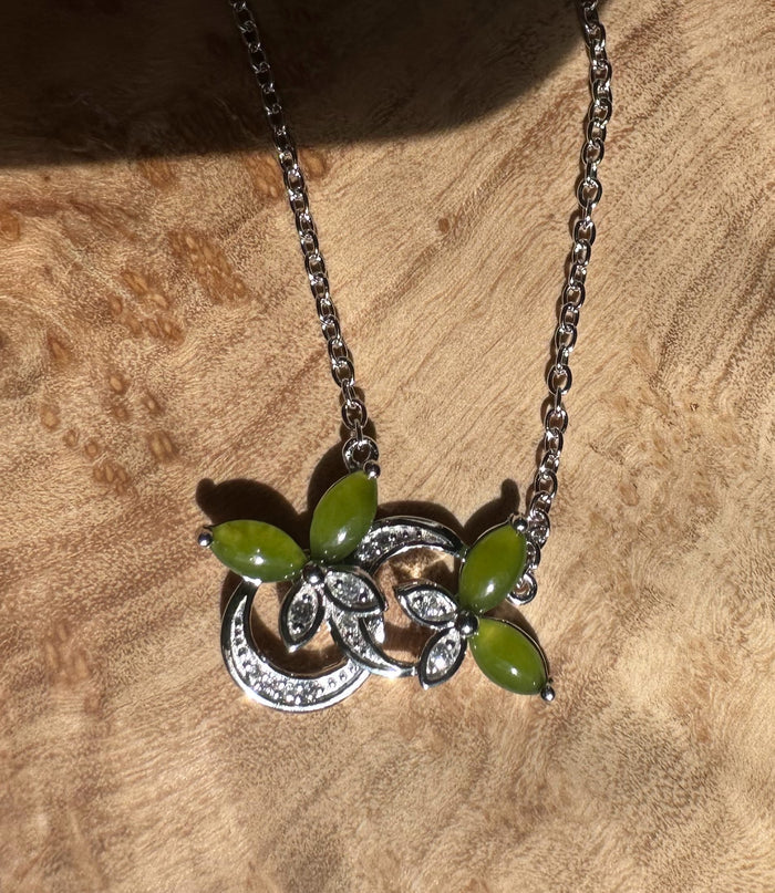 Silver butterfly pendant necklace with green marquise stones and crystal accents on a metal chain