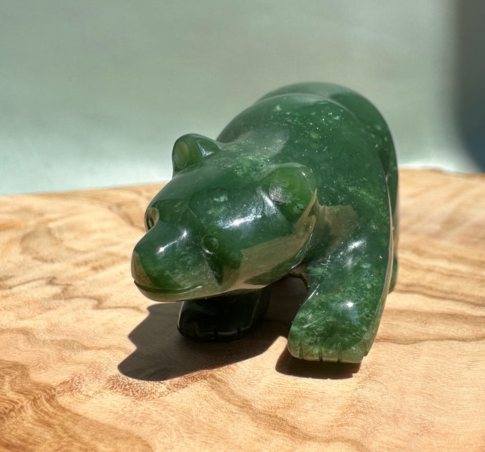 Closeup of the glossy green bear walking figurine from a front left angle