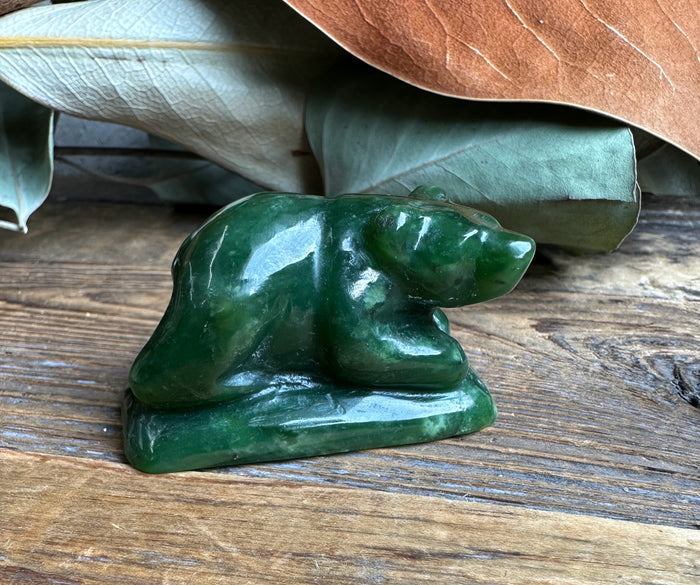 Front facing view of the green jade bear sculpture on a wooden surface