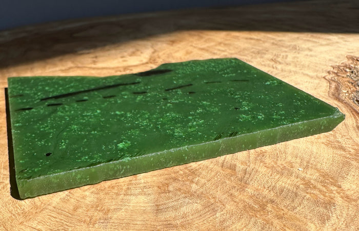 A Grade Canadian Cassiar Jade Slab in deep green on a wooden surface 130 grams