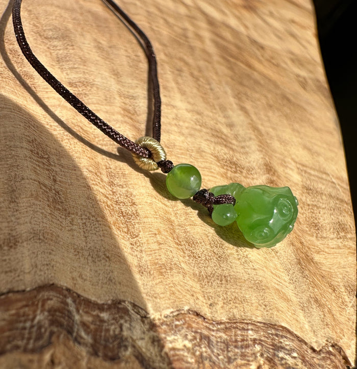 Emerald green jade lotus seed pod pendant on dark braided cord with beads