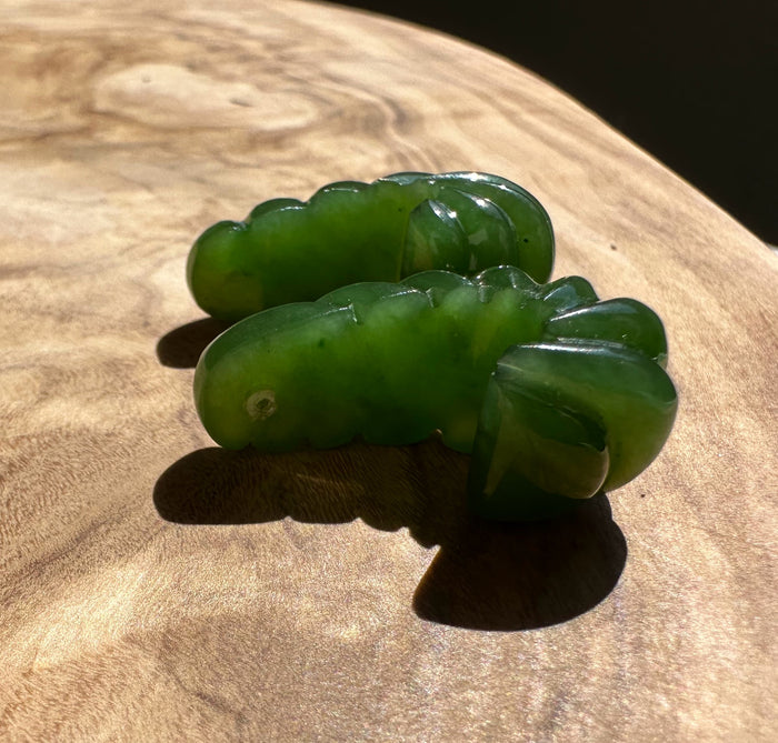 Green canandian jade fluted pair resting on a wooden surface