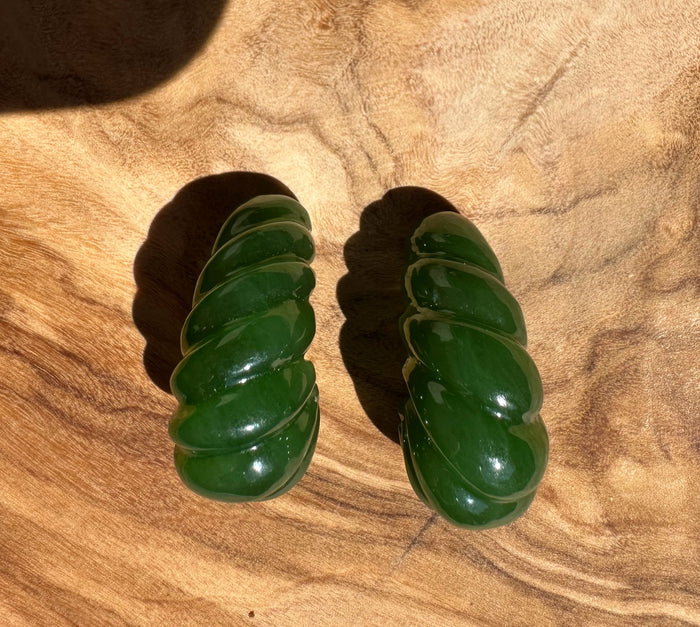 Two green canandian jade fluted pieces separated to reveal curved flutes