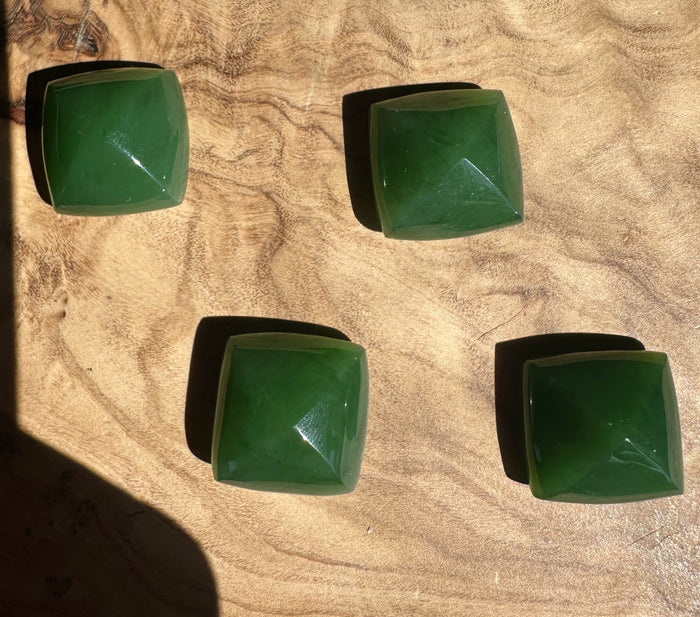 Four green square stones on a beige surface