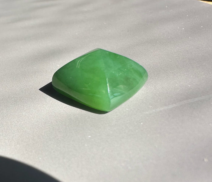 Green gemstone on a gray surface