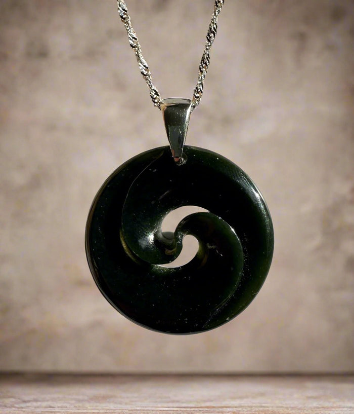 Dark green nephrite jade circular koru pendant on a silver chain
