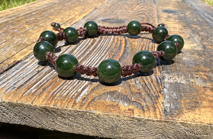 Green bead bracelet with large round beads on burgundy braided cord