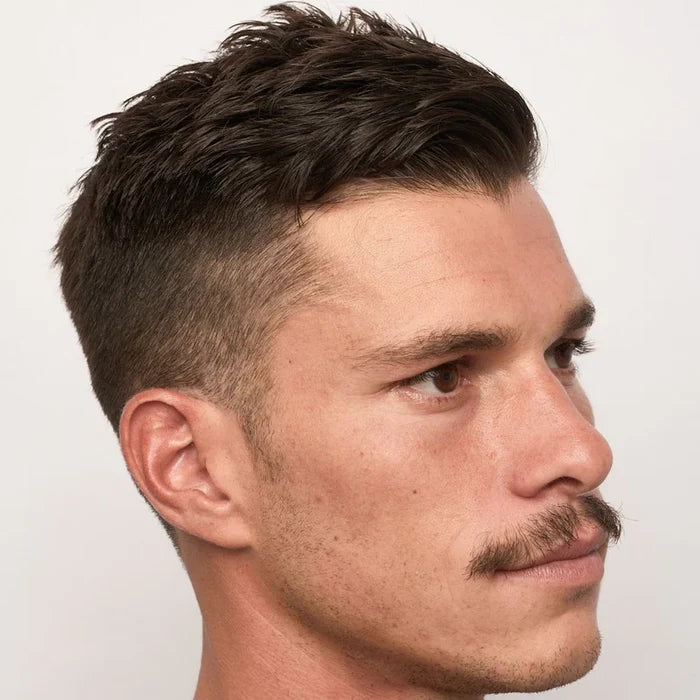 Mann med mustasj og lett skjegg som viser definisjon fra BYRD matte pomade