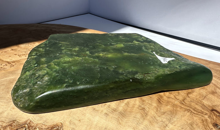 Green stone on a wooden surface with a white background