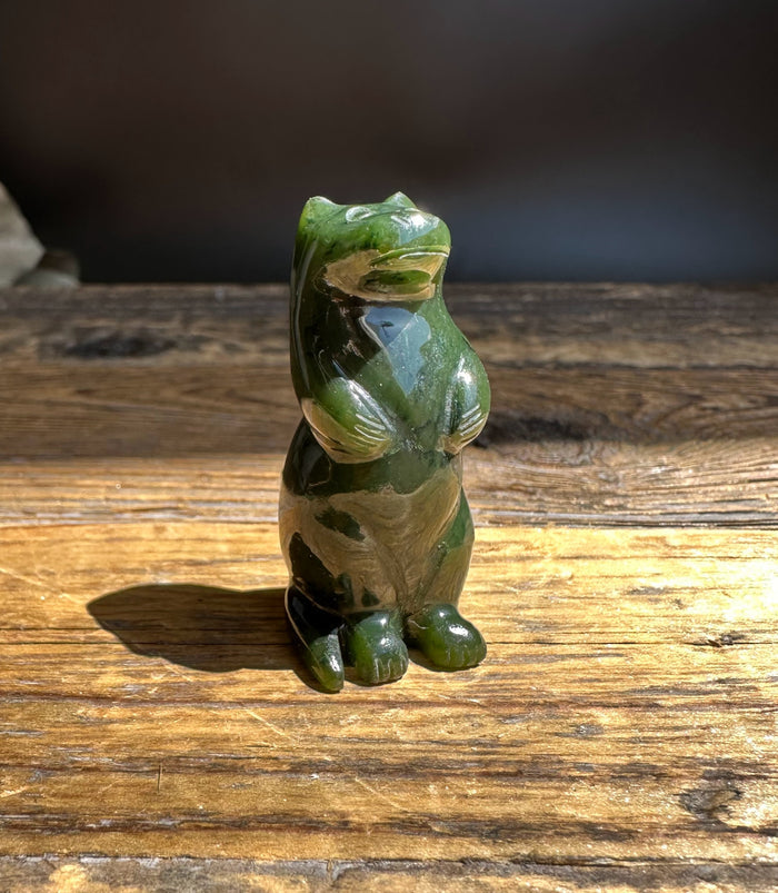 Canadian jade otter figurine carved in green tones resting on a wooden surface