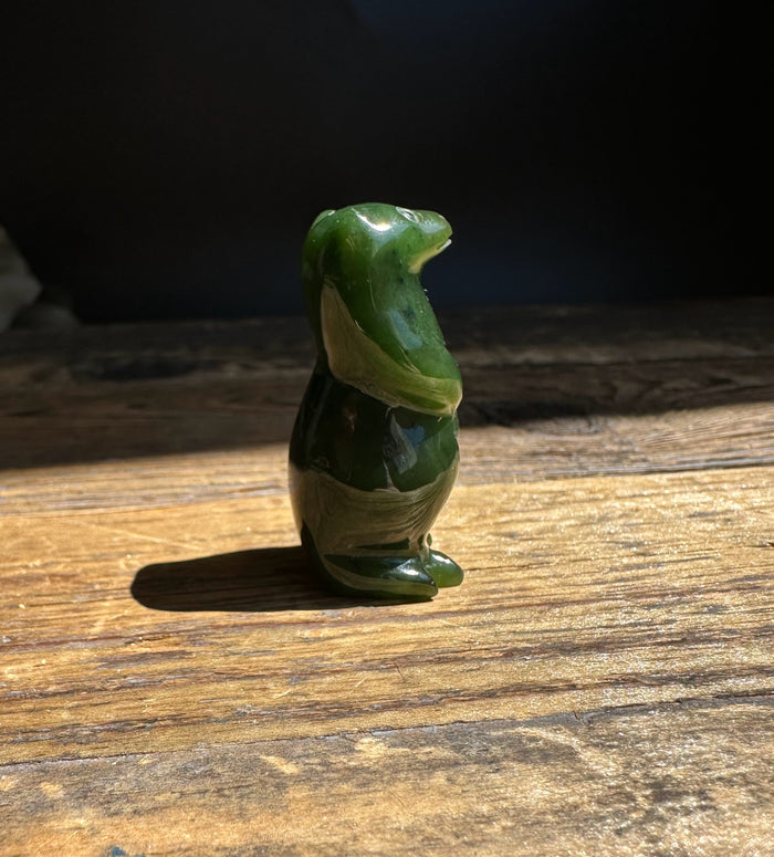Canadian Jade Otter figurine shown in profile on a weathered wooden table