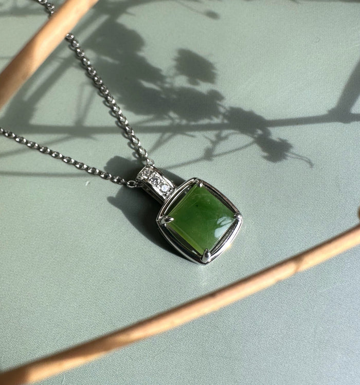 Canadian Jade pendant with a square green jade stone in a silver setting and a row of clear CZ stones on the bail