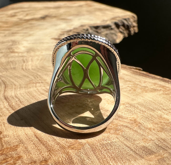 Back view of the jade ring showing intricate silver lattice setting around the green jade
