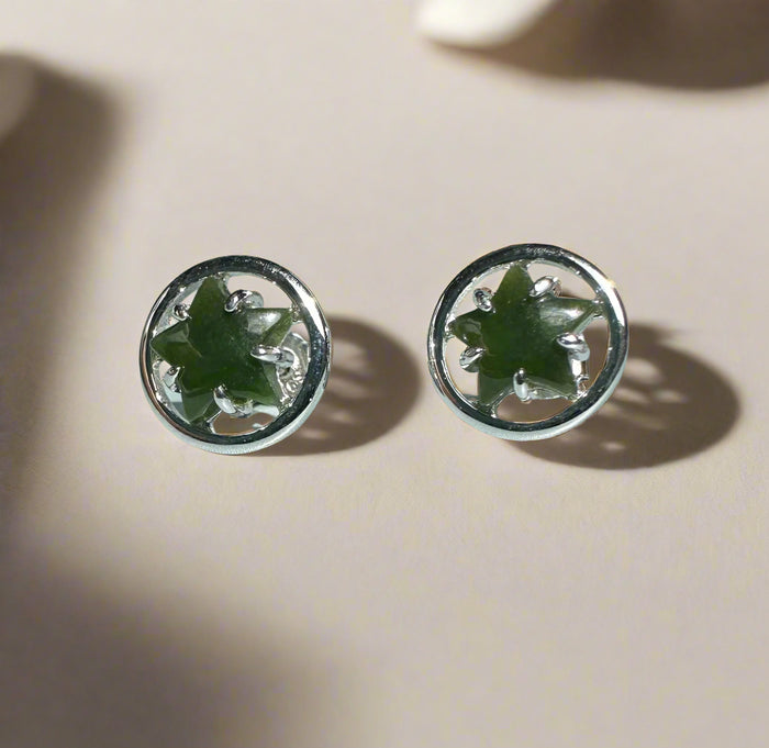 Pair of silver earrings with green jade on a light background