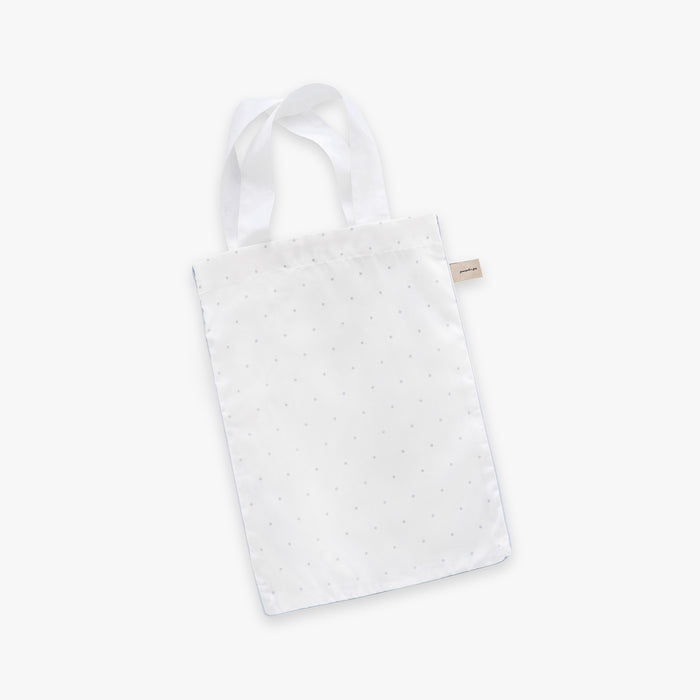 White tote bag with blue polka dot pattern on a white background