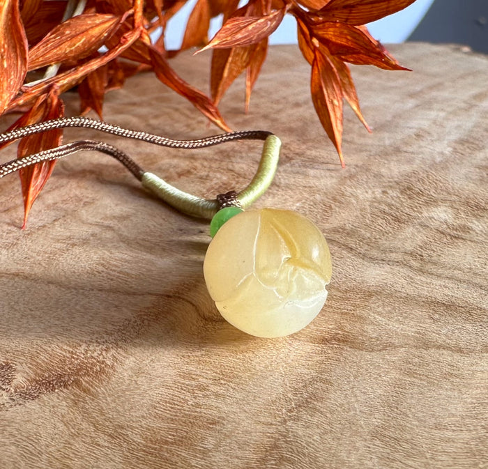Teardrop honey white nephrite jade pendant with green bead and decorative wrap on two tone cord