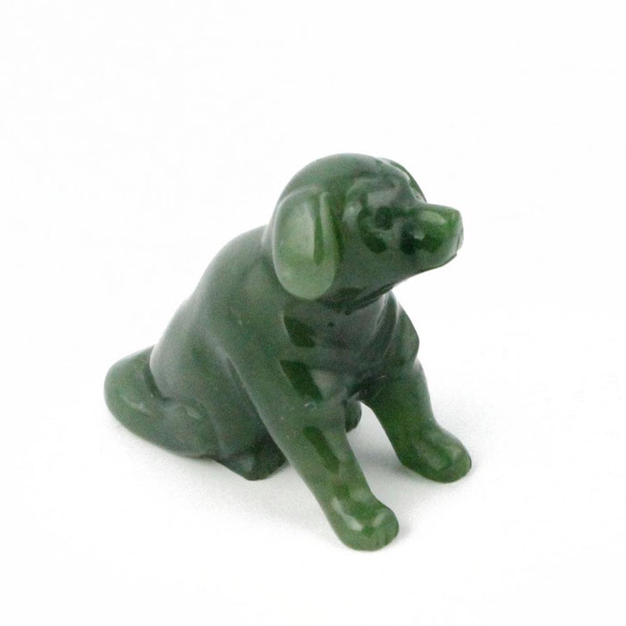 Small green Labrador retriever figurine sitting on a white surface.