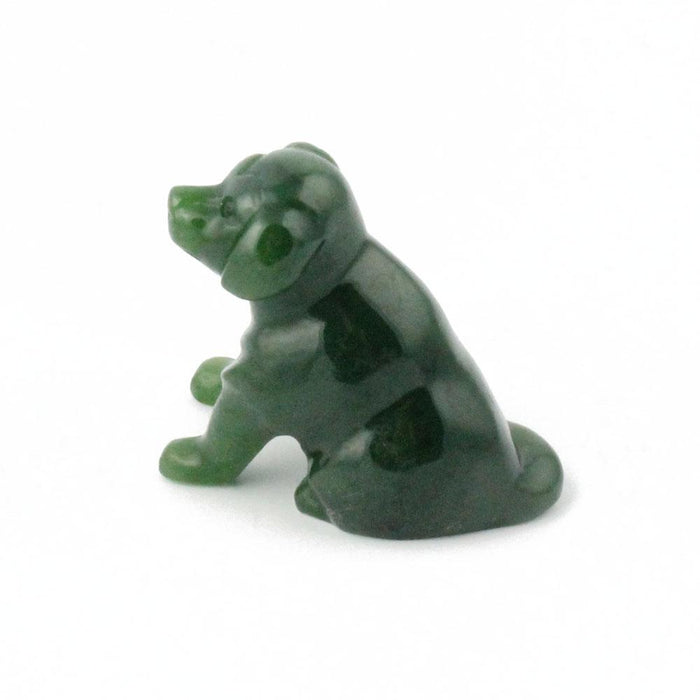 Green Labrador figurine in profile sitting on a white background.
