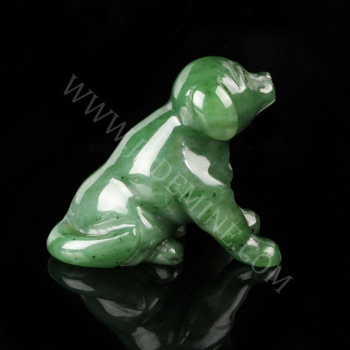 Profile view of a green jade Labrador retriever figurine in a seated pose on a black background