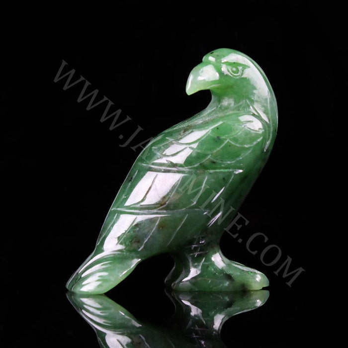 Green jade standing eagle sculpture with carved feathers on a black background