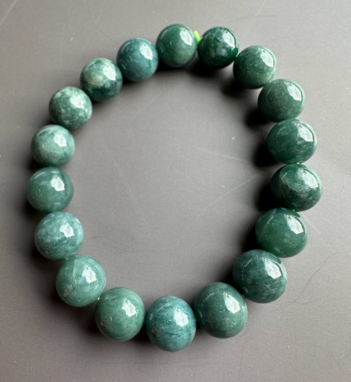 Guatemalan jadeite bead bracelet with 10mm round green beads on a gray background