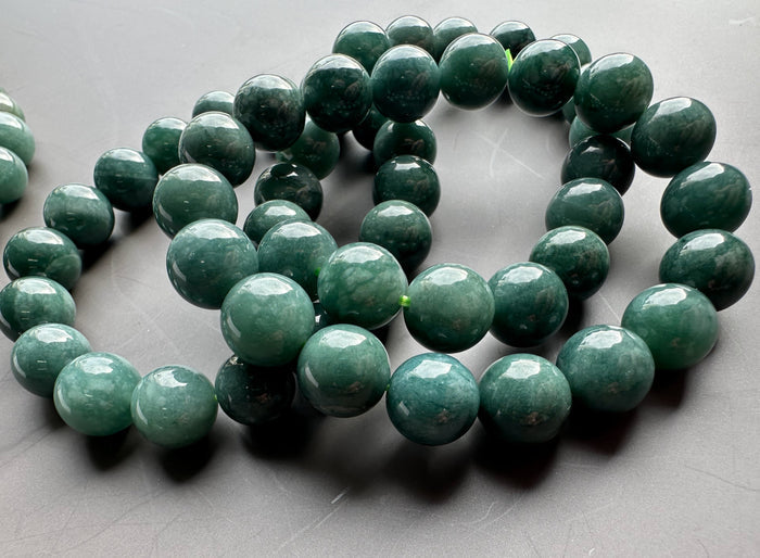 Guatemalan jadeite bead bracelet with 10mm glossy green beads coiled in a close up shot