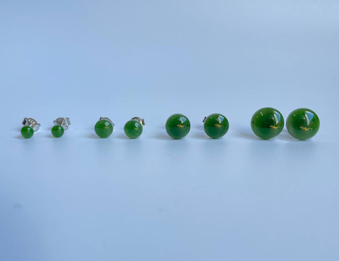 Jade flat stud earrings in multiple sizes arranged in a row from small to large