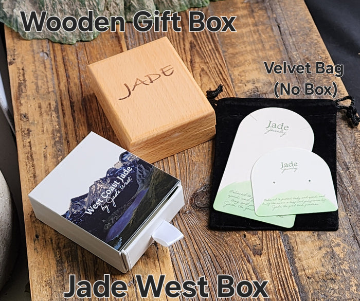 Packaging for Jade Infinity Twist pendant with wooden gift box and velvet bag on a wooden surface