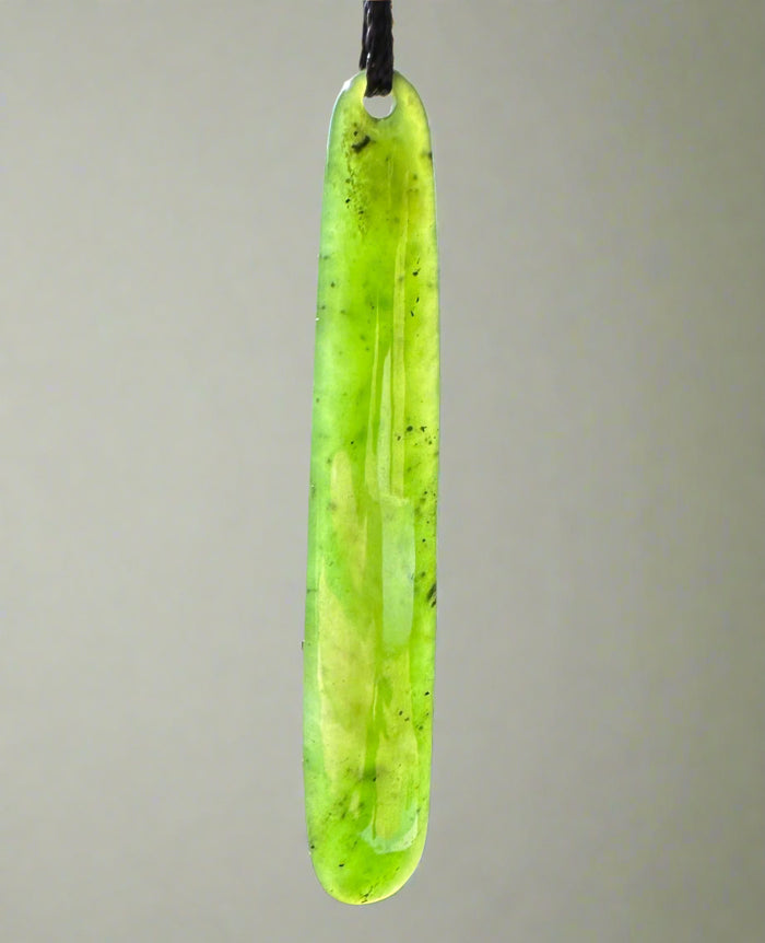 Long lime green jade pendant drop with a hole for cord on a black string.