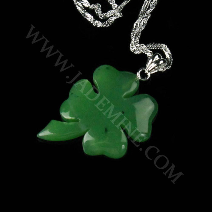 Green jade shamrock pendant with a silver bail on a chain against a black background