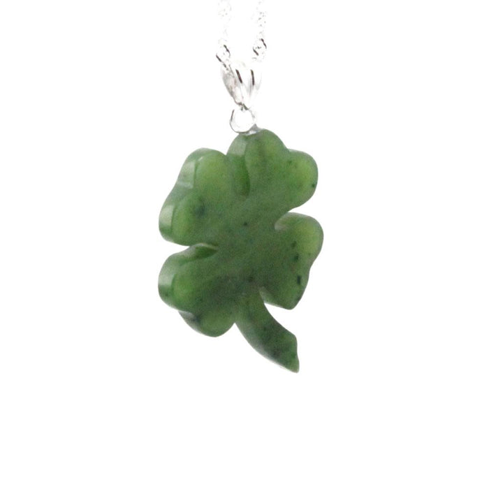 Green shamrock pendant on a silver bail against a white background
