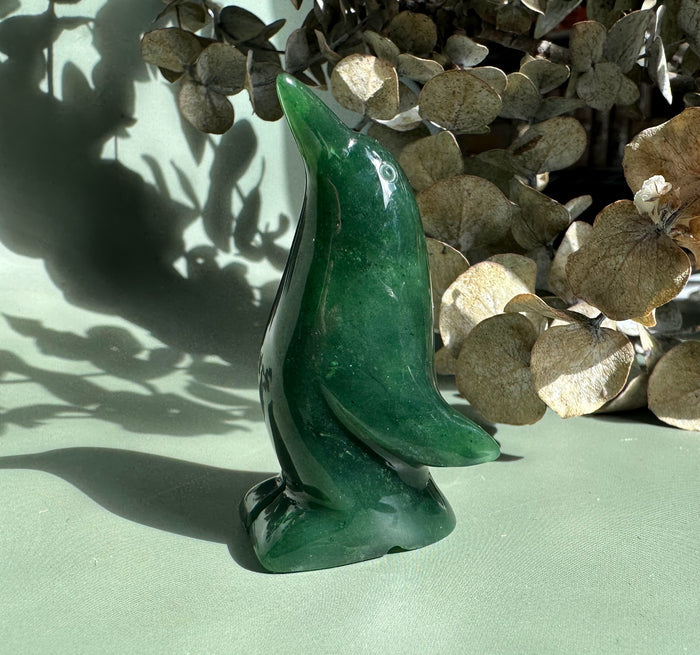 Glossy emerald penguin sculpture with a tall curved neck.