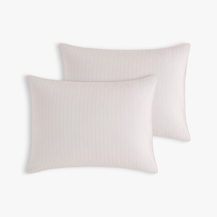 Two light pink pillows on a white background