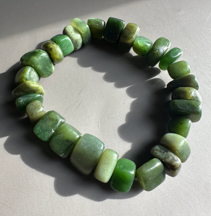 Close up of satin finish green nugget bracelet showing irregular square beads in varying greens