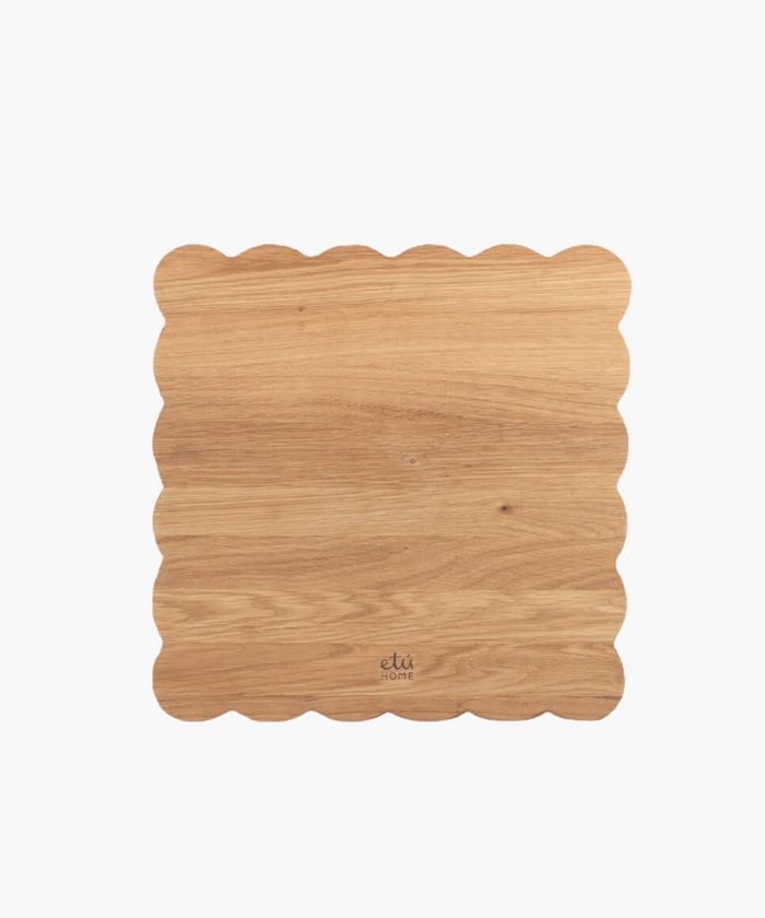 Scalloped-edge wooden cutting board with a light oak finish. | SW Home
