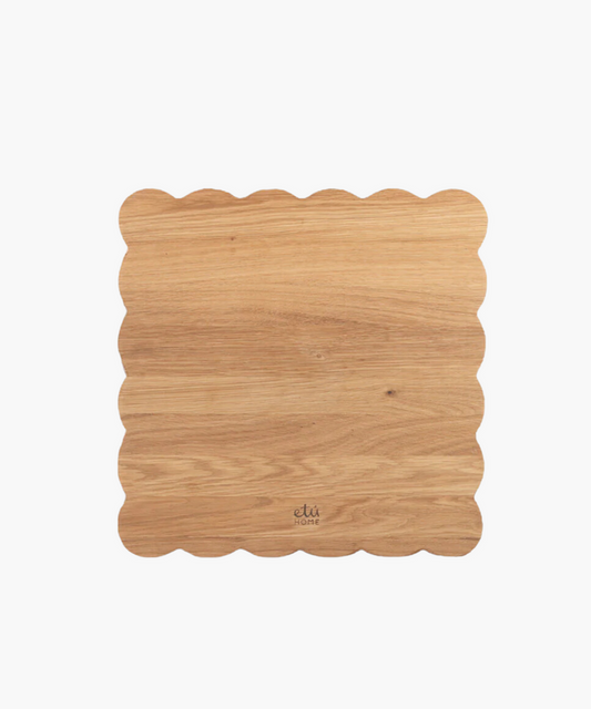 Scalloped-edge wooden cutting board with a light oak finish. | SW Home