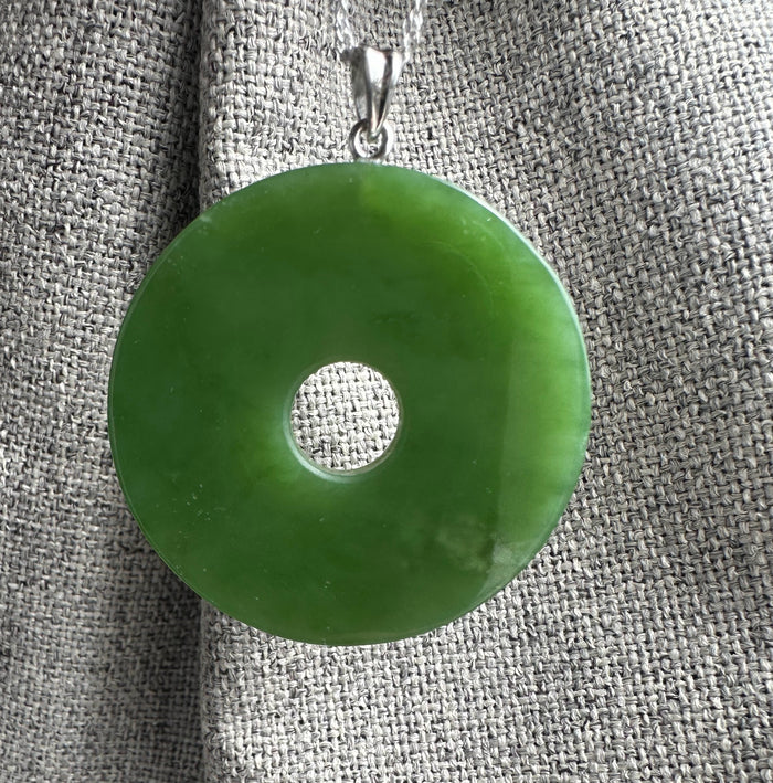 Silver chain necklace featuring a 40mm Siberian Jade Disc pendant against textured gray fabric.