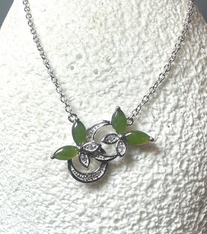 Silver butterfly pendant with green marquise stones and crystal accents on a silver chain.