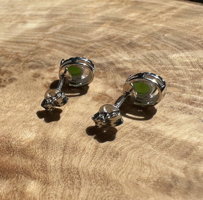 Side view of Silver Jade Studs showing green jade centers and diamond halos with posts and butterfly backs on suede