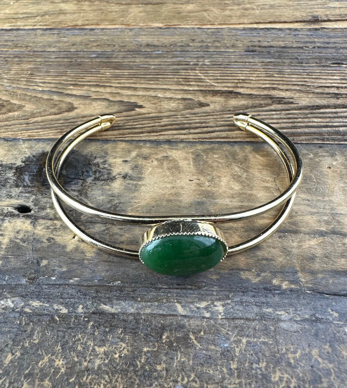 Vintage jade bracelet with a green oval cabochon centerpiece on a double silver bangle.