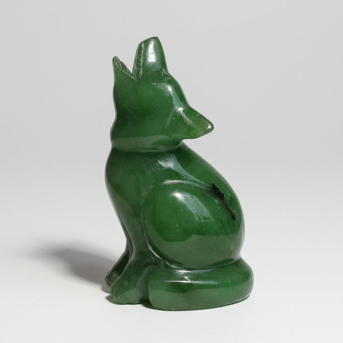 A small glossy green jade wolf figurine, shown in profile against a plain white background.