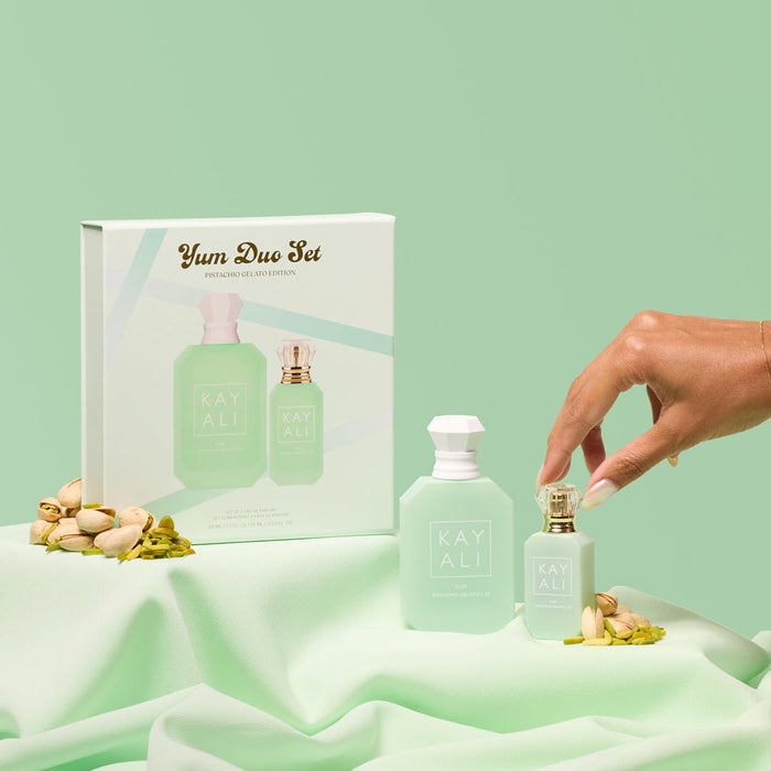 Kayali perfume set with packaging on a light green background